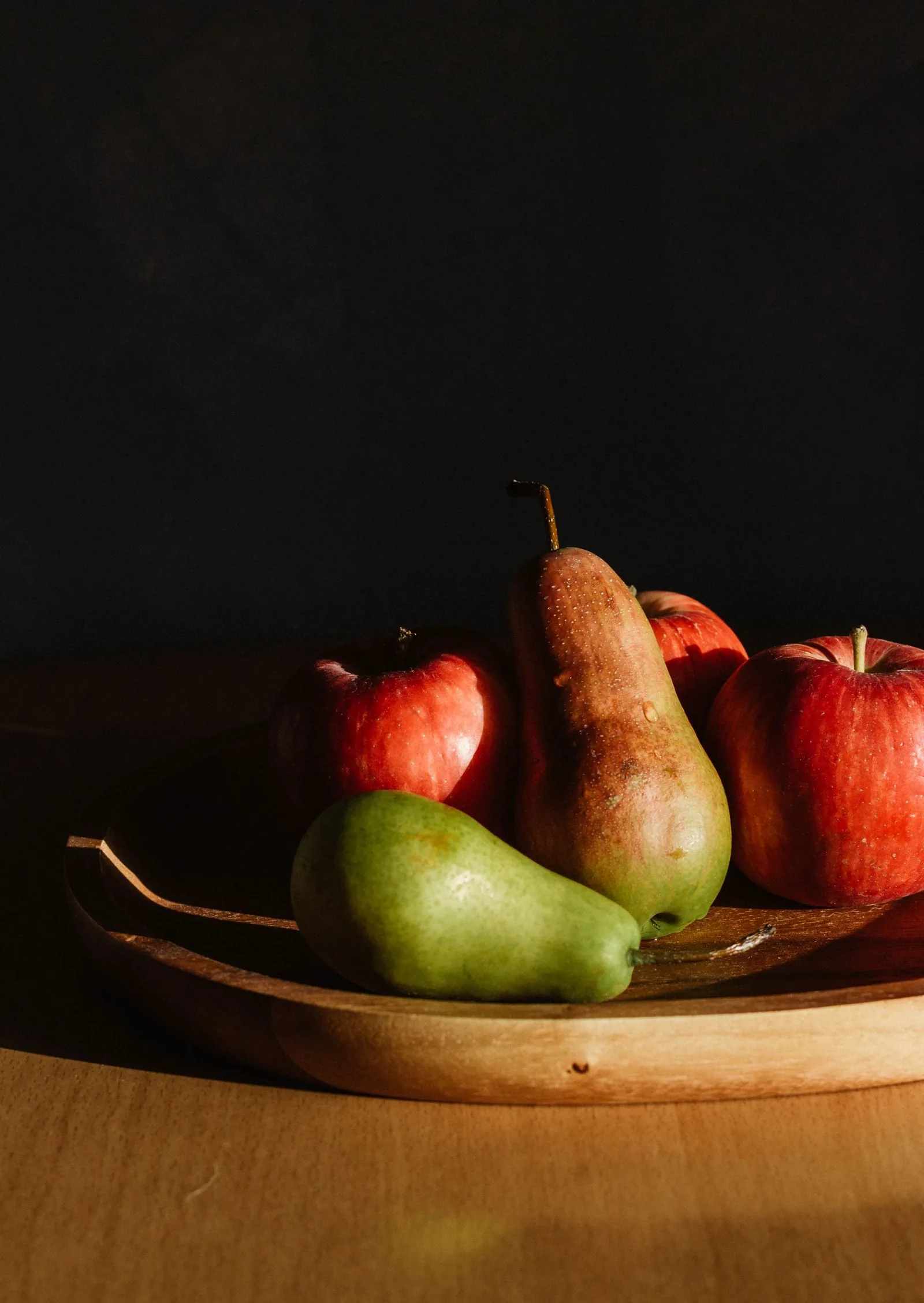Des pommes et des poires sur une planche en bois.